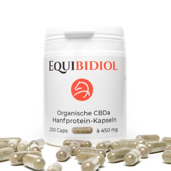 Produktfoto einer Packung Equibidol CBDa Caps mit 200 Kapseln Inhalt und davor liegenden Kapseln